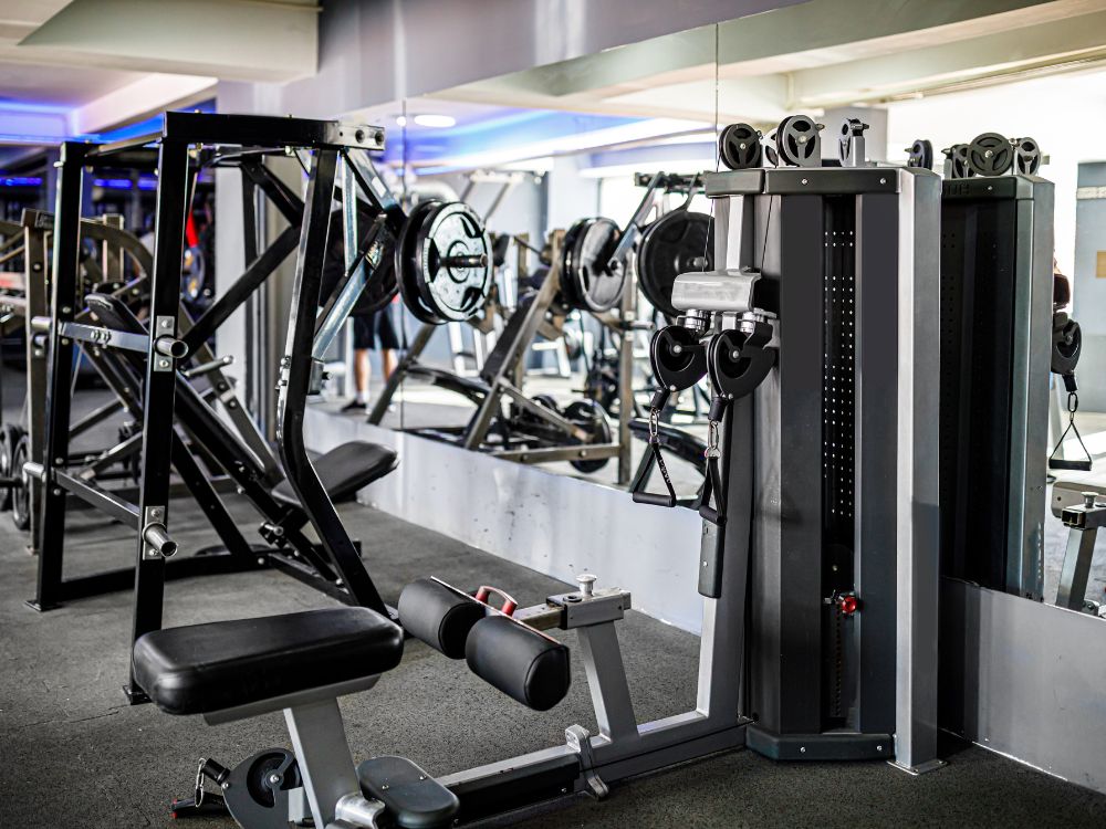 Academia equipada com máquinas de musculação e cabos de aço, destacando estrutura e uso ideal para quem busca saber qual o melhor cabo de aço para academia.